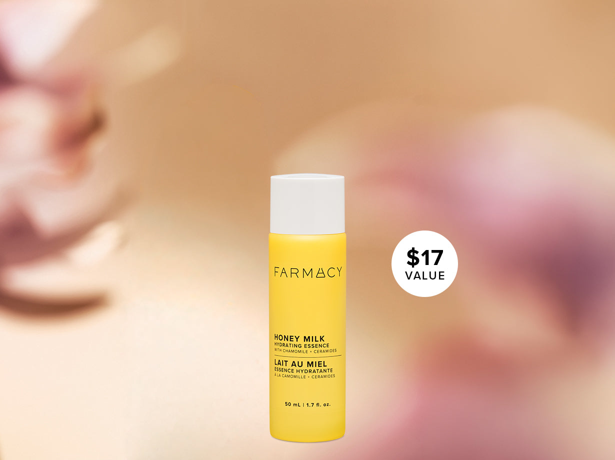 Farmacy Honey Milk Hydrating Essence 50 mL (1.7 fl. oz.) bottle with a $17 value badge against a softly blurred pink and gold background