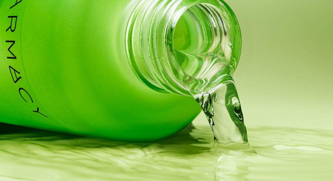 Green Deep Sweep Bottle with clear liquid being poured onto a light green background