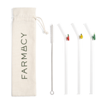 Fruitful Sips Glass Straw Set with three reusable bent glass straws, colorful decorative charms, a cleaning brush, and a Farmacy drawstring pouch on a white background