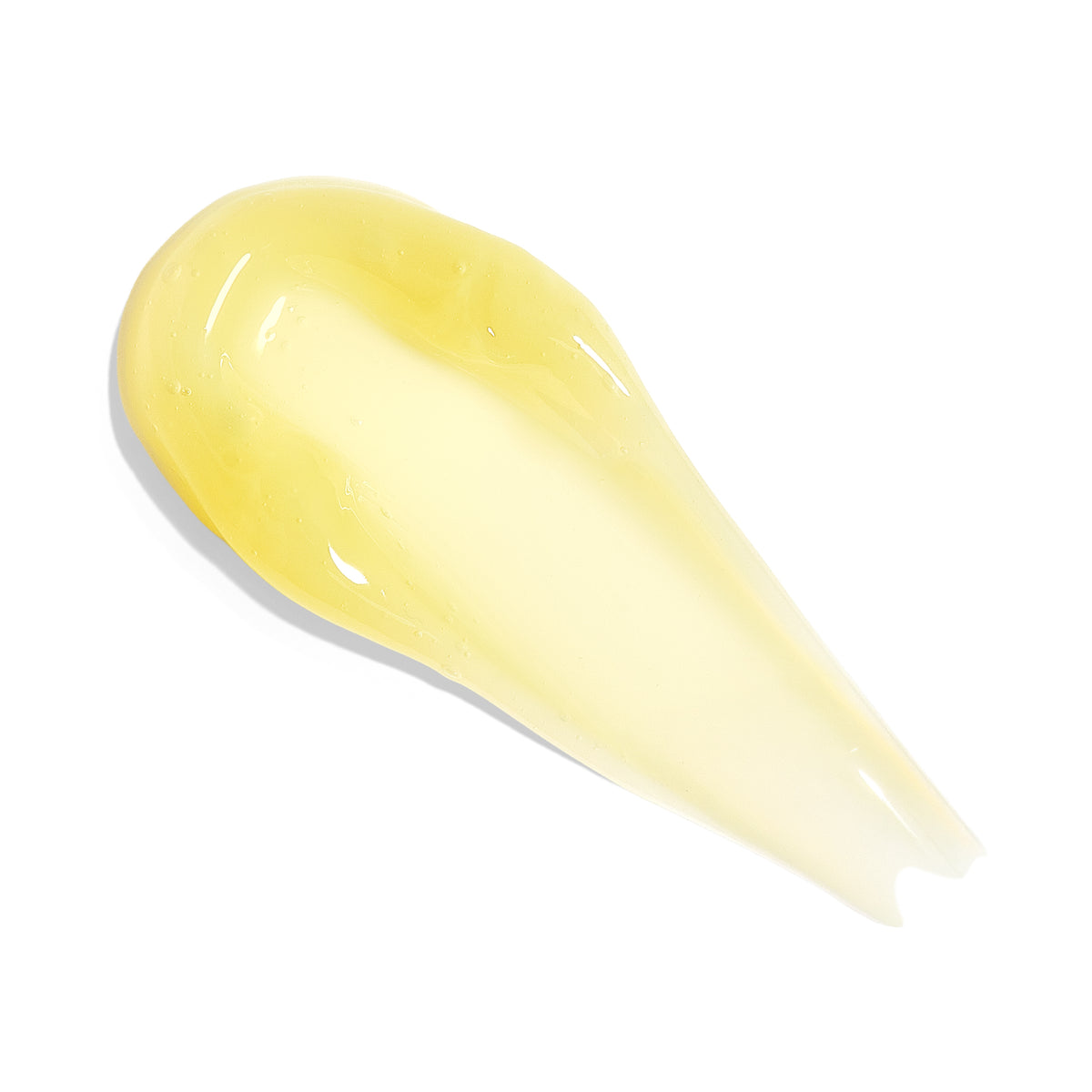 A smear of translucent, pale yellow cosmetic cream or gel on a solid white background.
