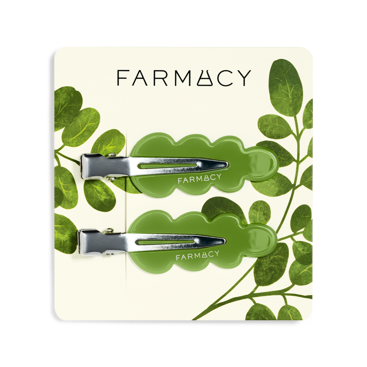 Two green wavy hair clips with silver metal clasps and the brand name 'FARMACY' shown on a clean white background