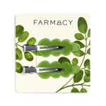 Two green wavy hair clips with silver metal clasps and the brand name 'FARMACY' shown on a clean white background