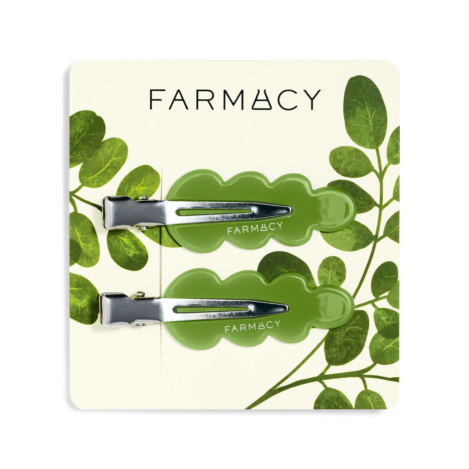 Two green wavy hair clips with silver metal clasps and the brand name 'FARMACY' shown on a clean white background