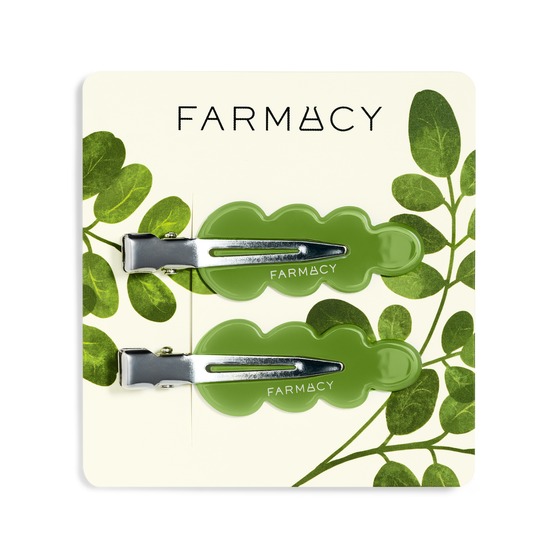 Two green wavy hair clips with silver metal clasps and the brand name 'FARMACY' shown on a clean white background