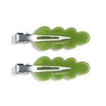 Two green wavy hair clips with silver metal clasps and the brand name 'FARMACY' shown on a clean white background