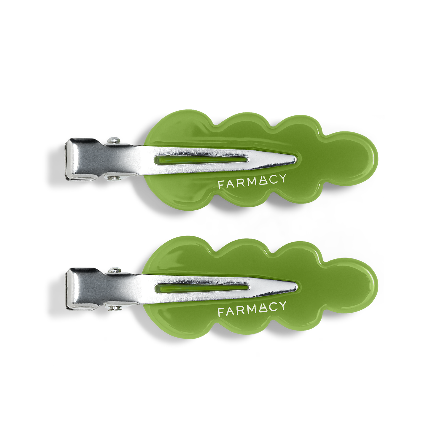 Two green wavy hair clips with silver metal clasps and the brand name 'FARMACY' shown on a clean white background