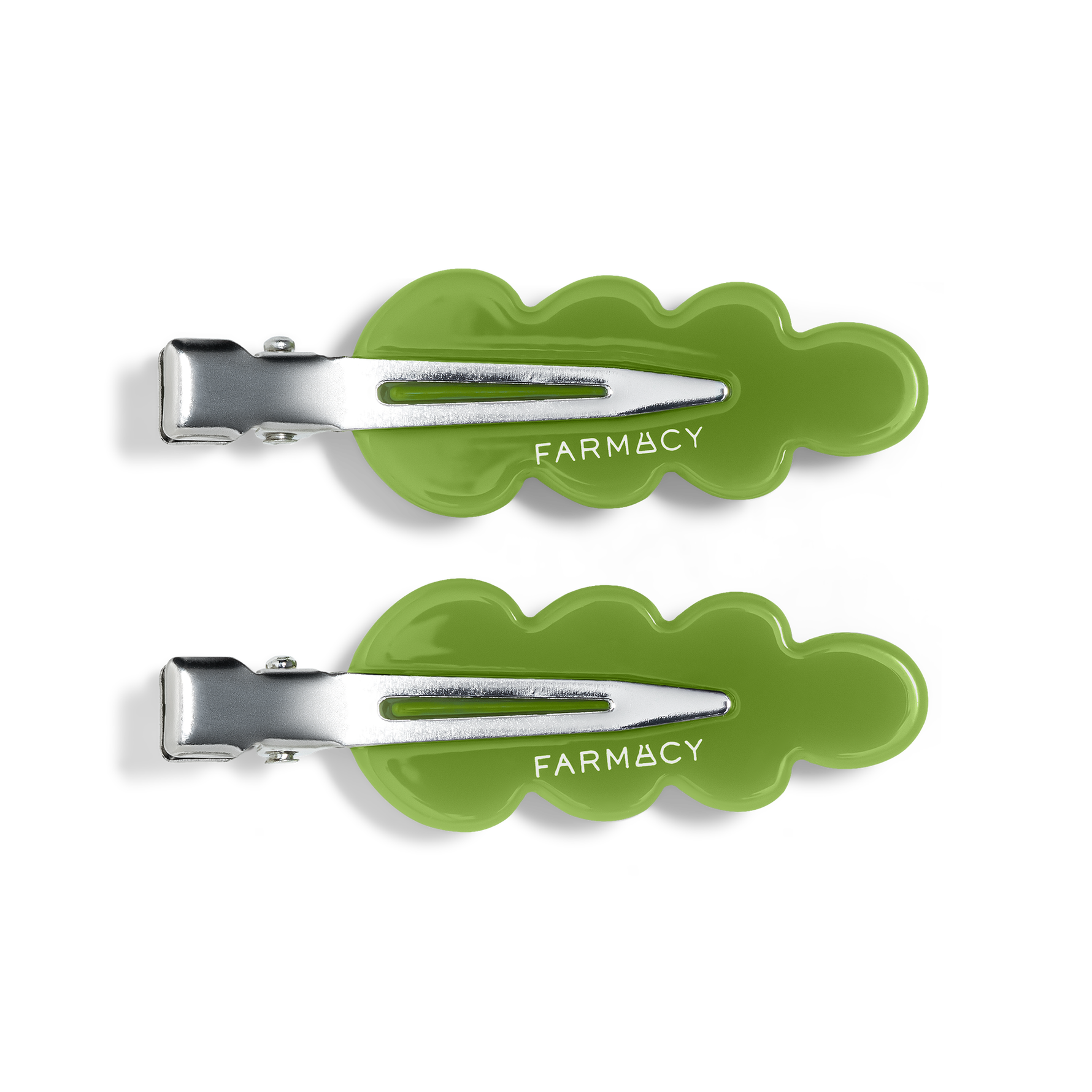 Two green wavy hair clips with silver metal clasps and the brand name 'FARMACY' shown on a clean white background