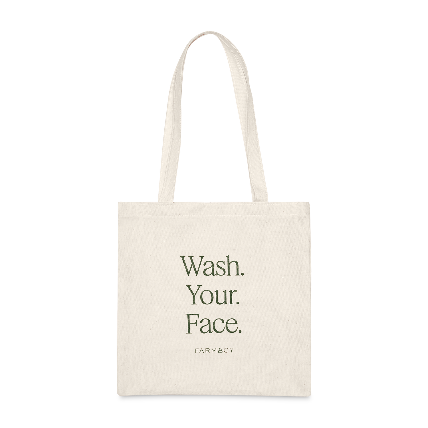 An off-white canvas tote bag with long handles, featuring the text 'Wash Your Face'' with the Farmacy logo on a white background