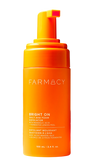 Orange bottle of Farmacy skincare product on a white background