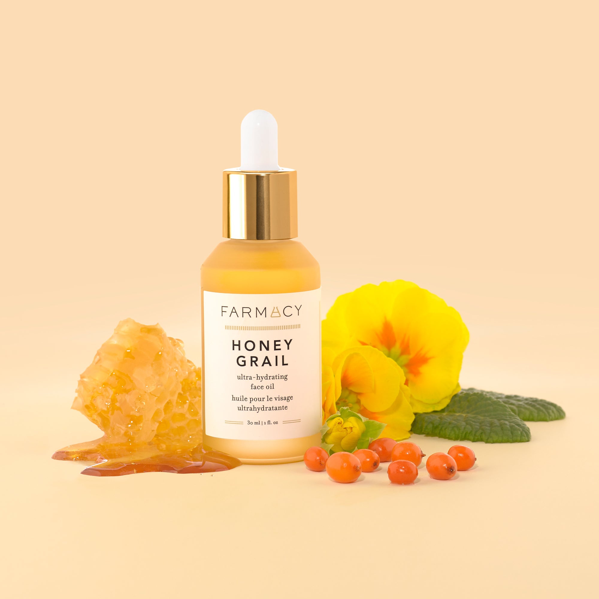 a bottle of Farmacy's Honey Grail standing in front of a hibiscus flower and honey