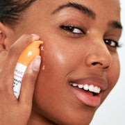 A women applying the 10% Waterless Vitamin C Serum to her face