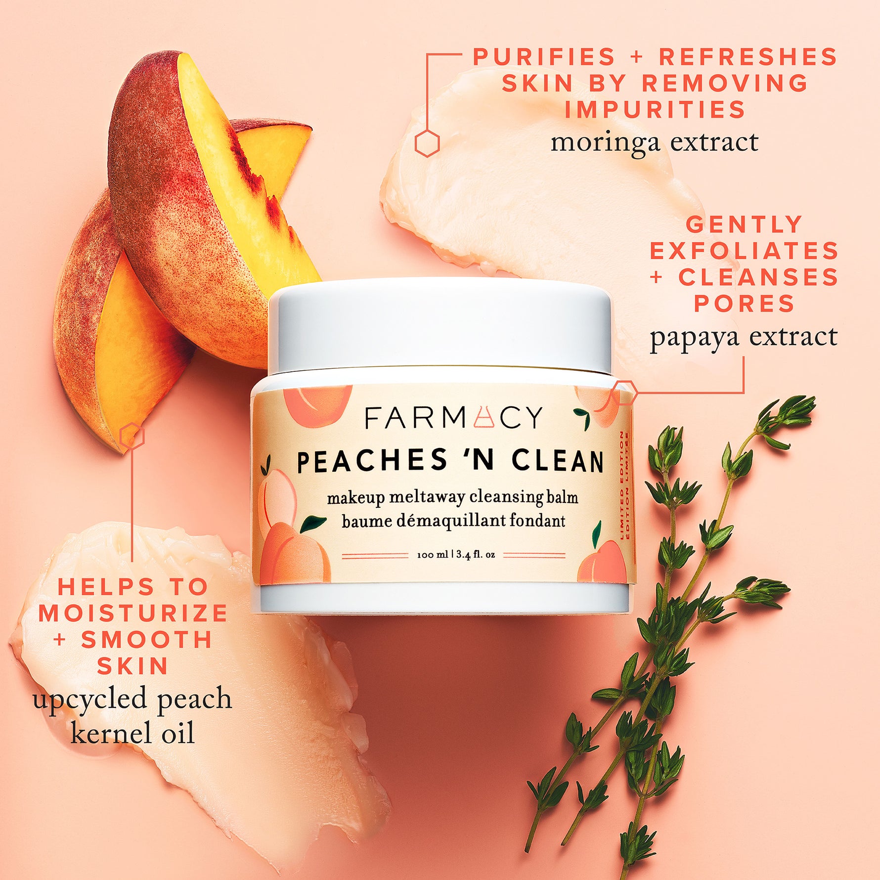 Peaches ’N Clean Makeup Meltaway Cleansing Balm in its closed container surrounded by peach slices, herbs, and two smears of cleansing balm on a light pink surface